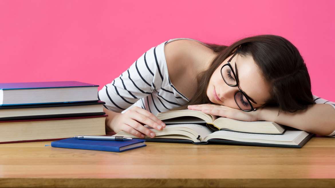 Etudiante dormant sur des livres